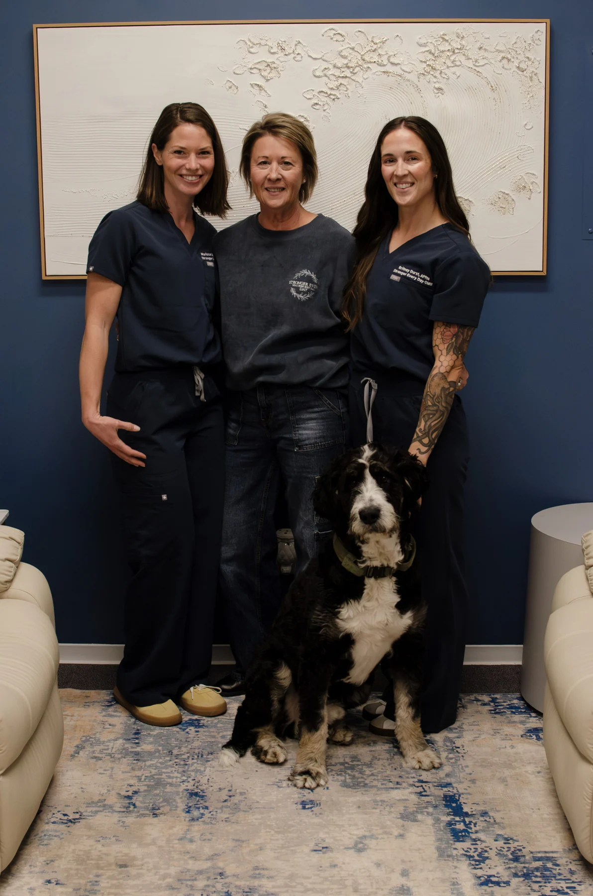 Three people with a dog inside a clinic