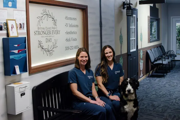 Two team members seated beside the Stronger Every Day practice sign